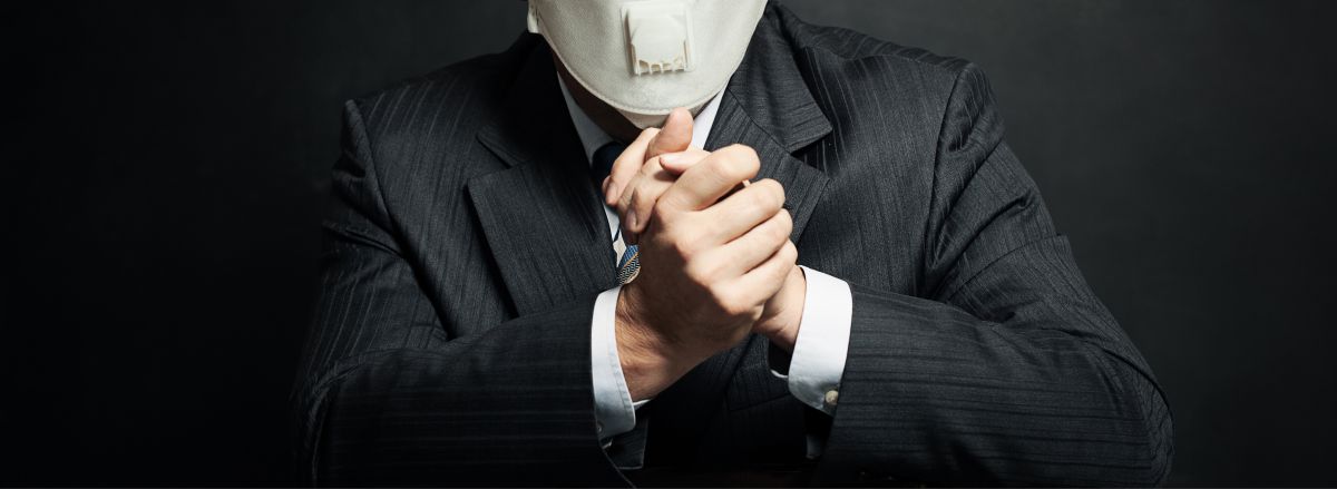 man in business suit wearing medical face mask
